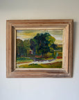 A framed vintage landscape oil painting featuring a prominent green tree, grassy fields, and a winding light-colored path under a yellow and blue sky, housed in a rustic, weathered wooden frame. Available at Hue. 