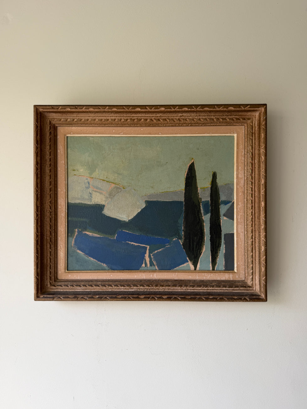 A framed abstract landscape painting featuring dark blue shapes and two tall black cypress trees, housed in an ornate gold-toned wooden frame. Available at Hue. 
