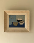 A framed abstract oil painting featuring blue, beige, and black geometric shapes and bowl-like forms. Available at Hue.