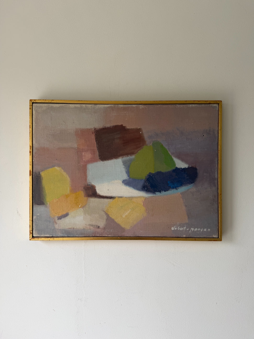 An abstract vintage  still life oil painting in a gold frame. The painting features geometric shapes in brown, beige, yellow, green, blue, and white. Available at Hue. 