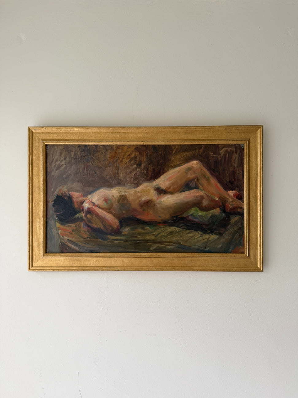 A framed vintage oil painting of a reclining nude figure, housed in a gold frame. Available at Hue. 
