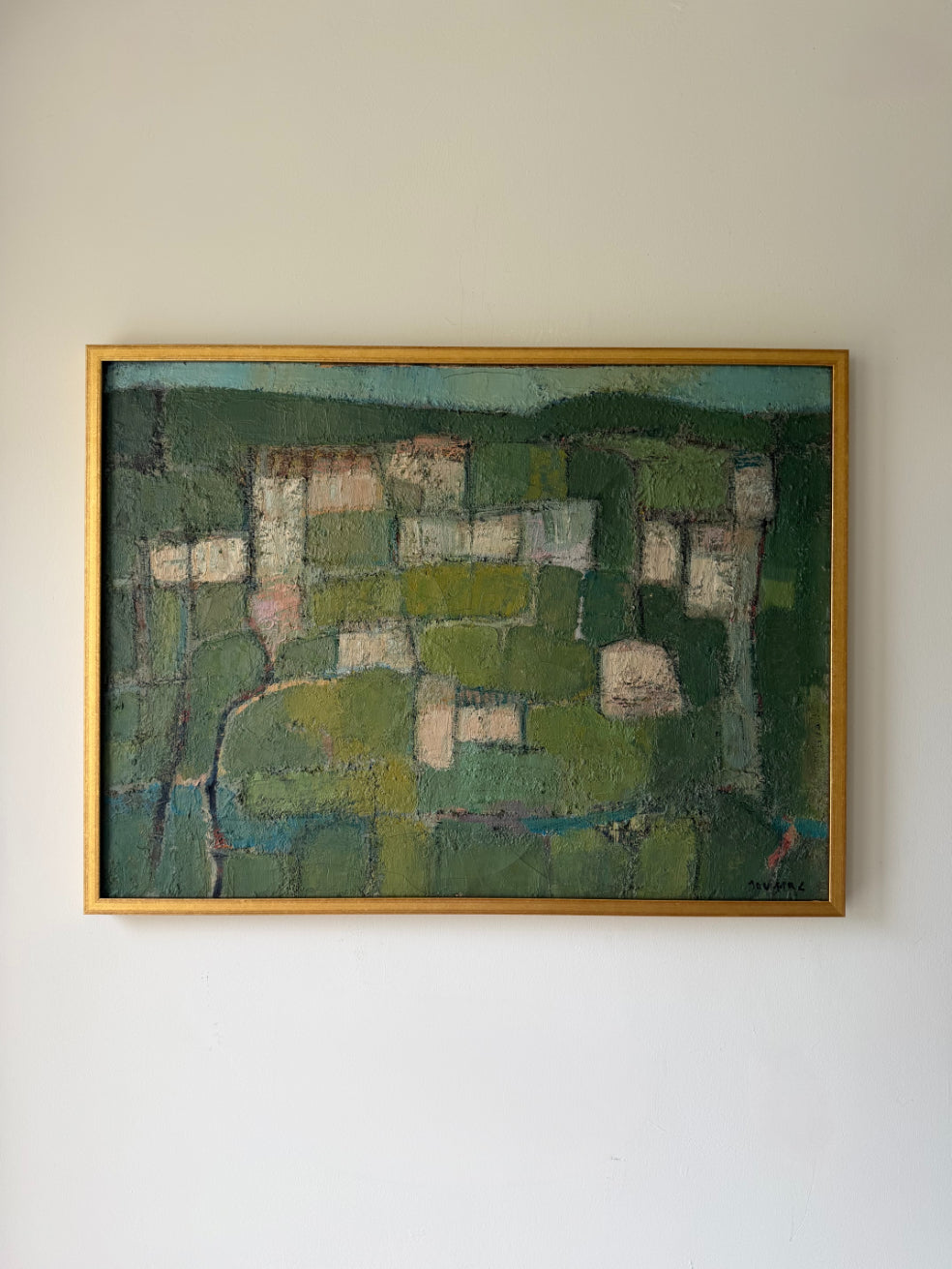 A framed vintage abstract landscape painting in a gold frame, featuring textured green fields and patches of beige and blue. Available at Hue. 