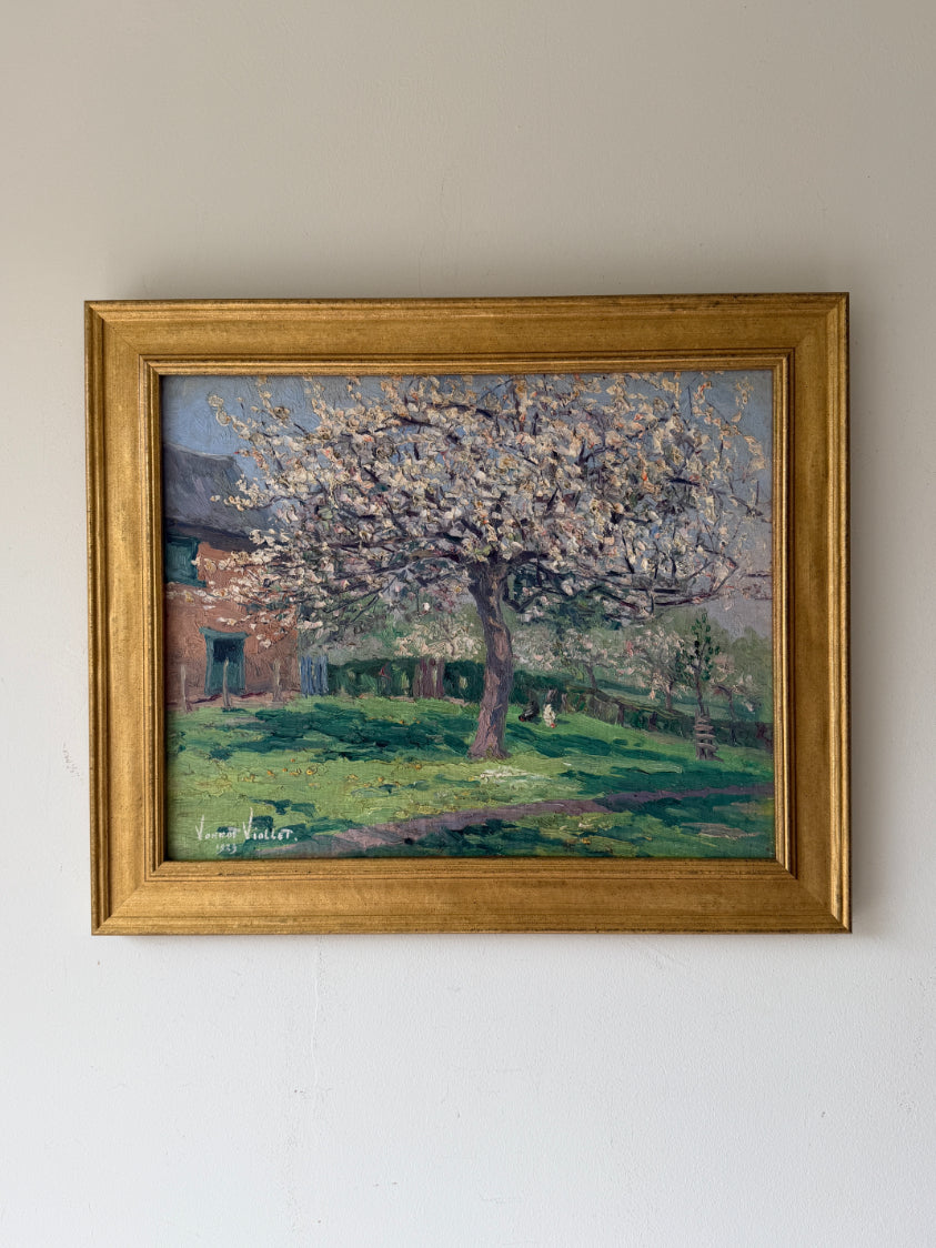 A framed vintage impressionist landscape oil painting of a blossom tree in a grassy yard, housed in a gold frame. Available at Hue. 