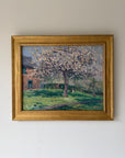 A framed vintage impressionist landscape oil painting of a blossom tree in a grassy yard, housed in a gold frame. Available at Hue. 