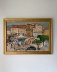 A framed vintage impressionist oil painting of a French town square, featuring buildings with terracotta roofs, market stalls, trees, and a dark car, enclosed in a gold frame. Available at Hue. 