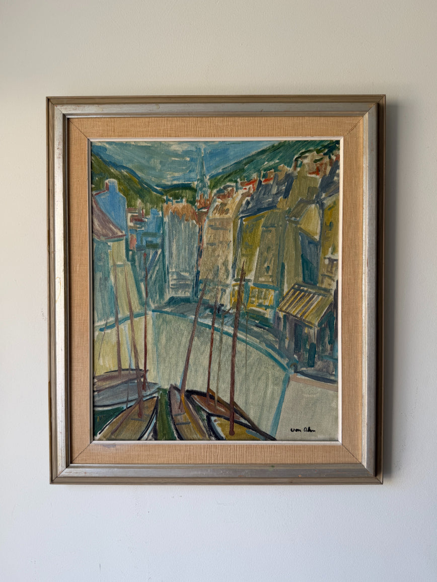 A framed vintage oil painting of a harbor scene with boats, buildings, and hills. Available at Hue. 