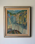 A framed vintage oil painting of a harbor scene with boats, buildings, and hills. Available at Hue. 