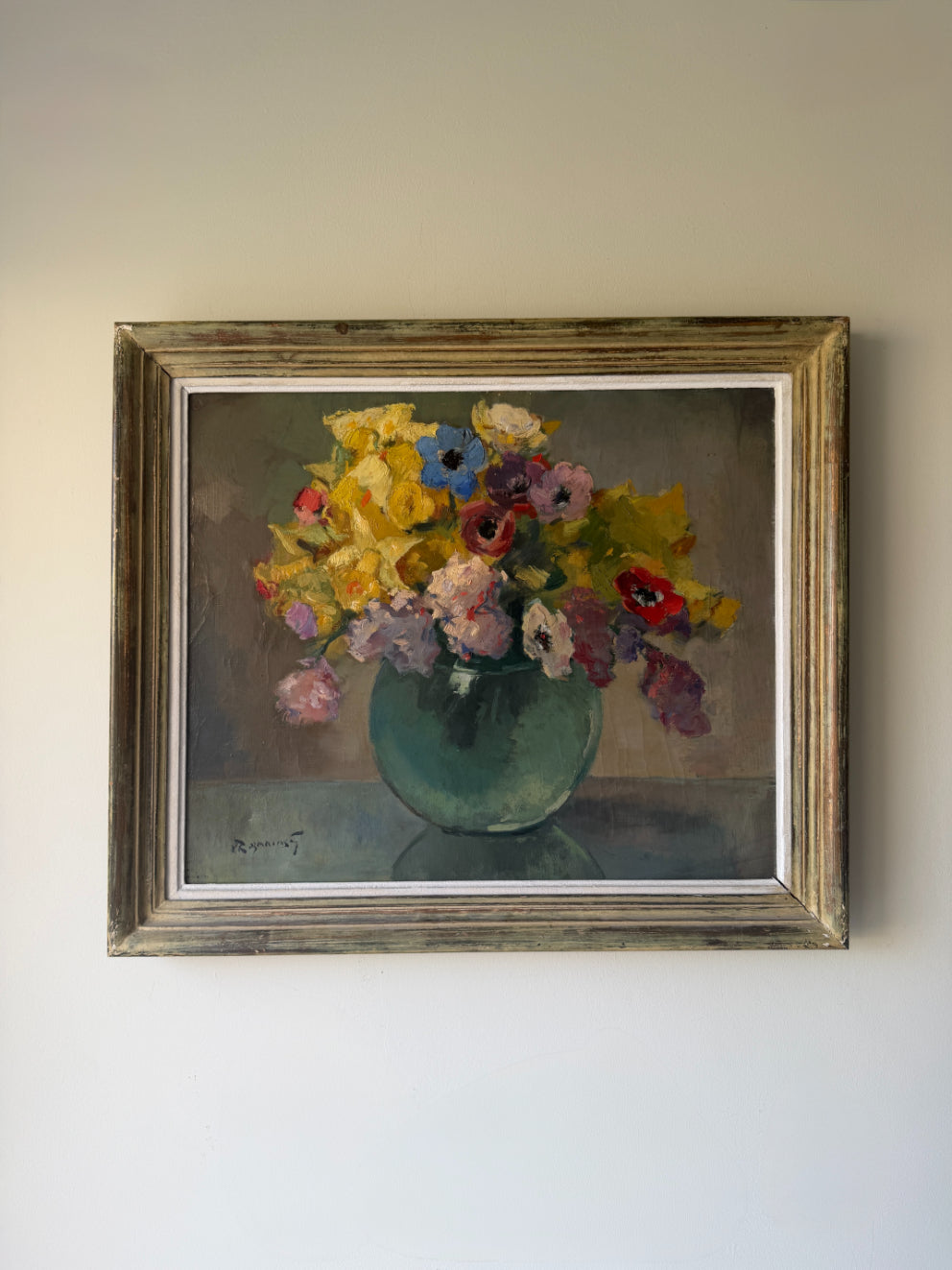 A large framed vintage still life oil painting of colourful florals in a green round vase. Available at Hue. 