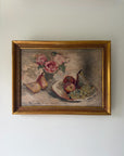 A framed vintage still life oil painting featuring pears, apples, and a bouquet of pink roses, housed in a gold-coloured frame. Available at Hue. 