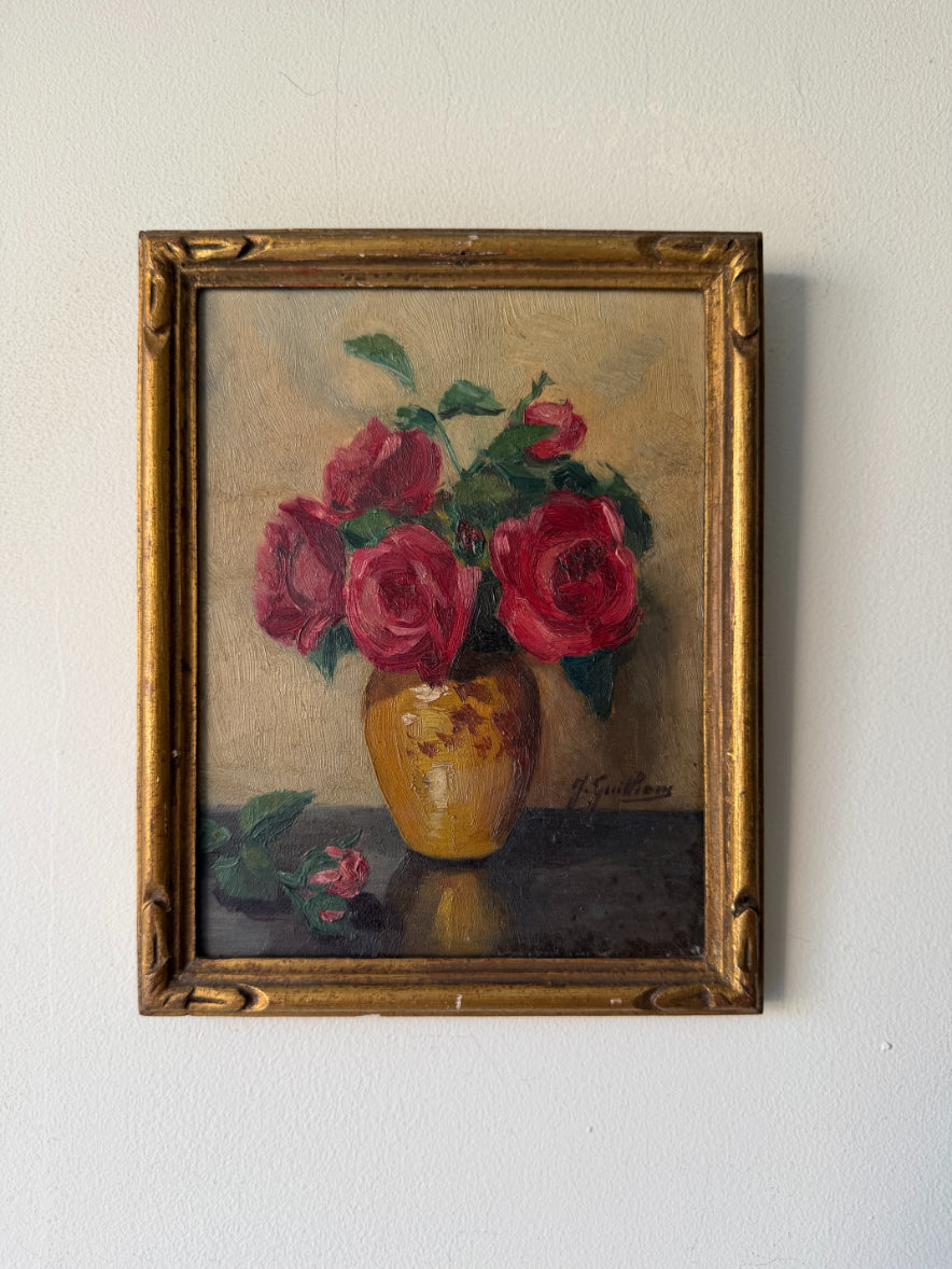 A framed vintage oil painting of red roses in a yellow vase. Available at Hue. 