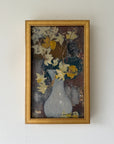 A framed vintage still life oil painting of a white vase with yellow and white flowers. Available at Hue. 