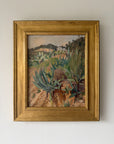 A framed vintage landscape oil painting featuring green succulents and cacti in a dry, rocky terrain, housed in a wide, ornate gold frame. Available at Hue.