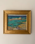 A framed vintage coastal landscape painting featuring turquoise water, rocky shoreline, and a dark blue horizon, housed in a wide ornate gold frame. Available at Hue. 