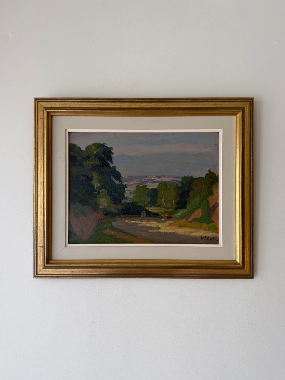 Framed vintage oil landscape painting of trees and a distant village. Available at Hue. 