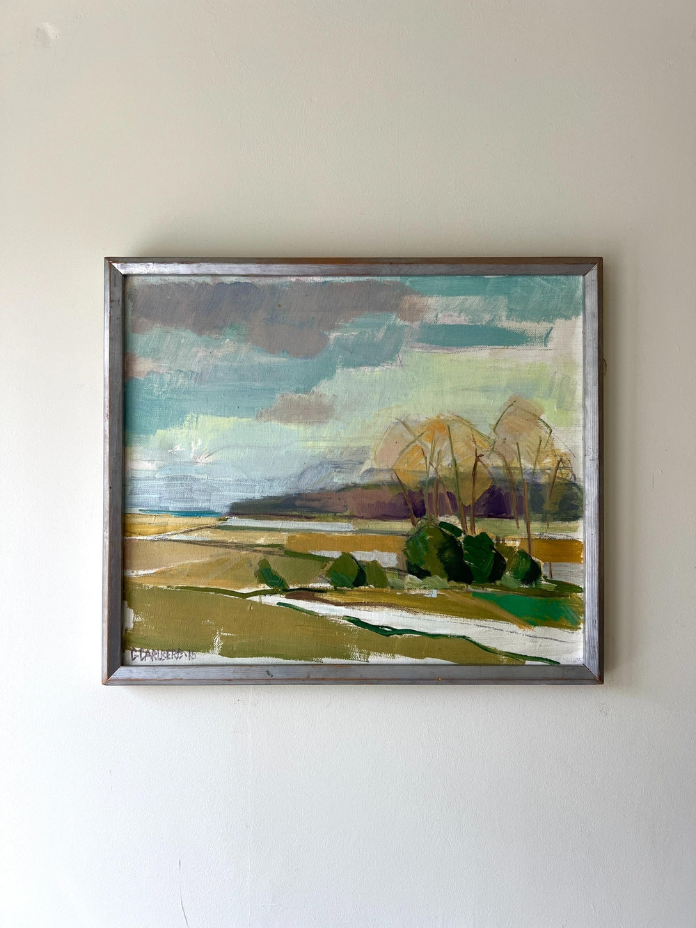 Framed landscape painting of a winter scene with fields and trees on a white wall available from hue
