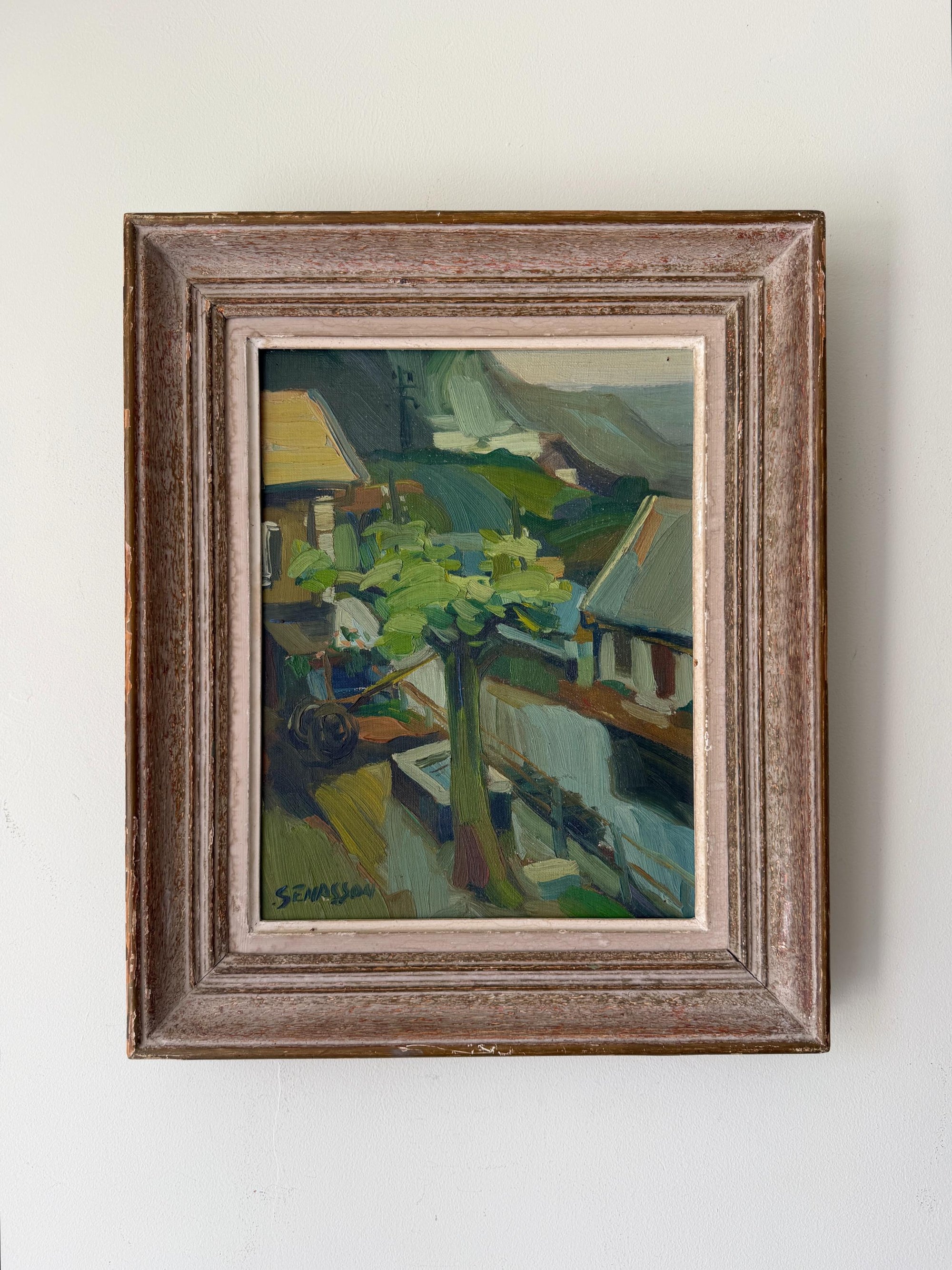 Framed vintage oil painting of hillside houses and trees. Available at Hue. 