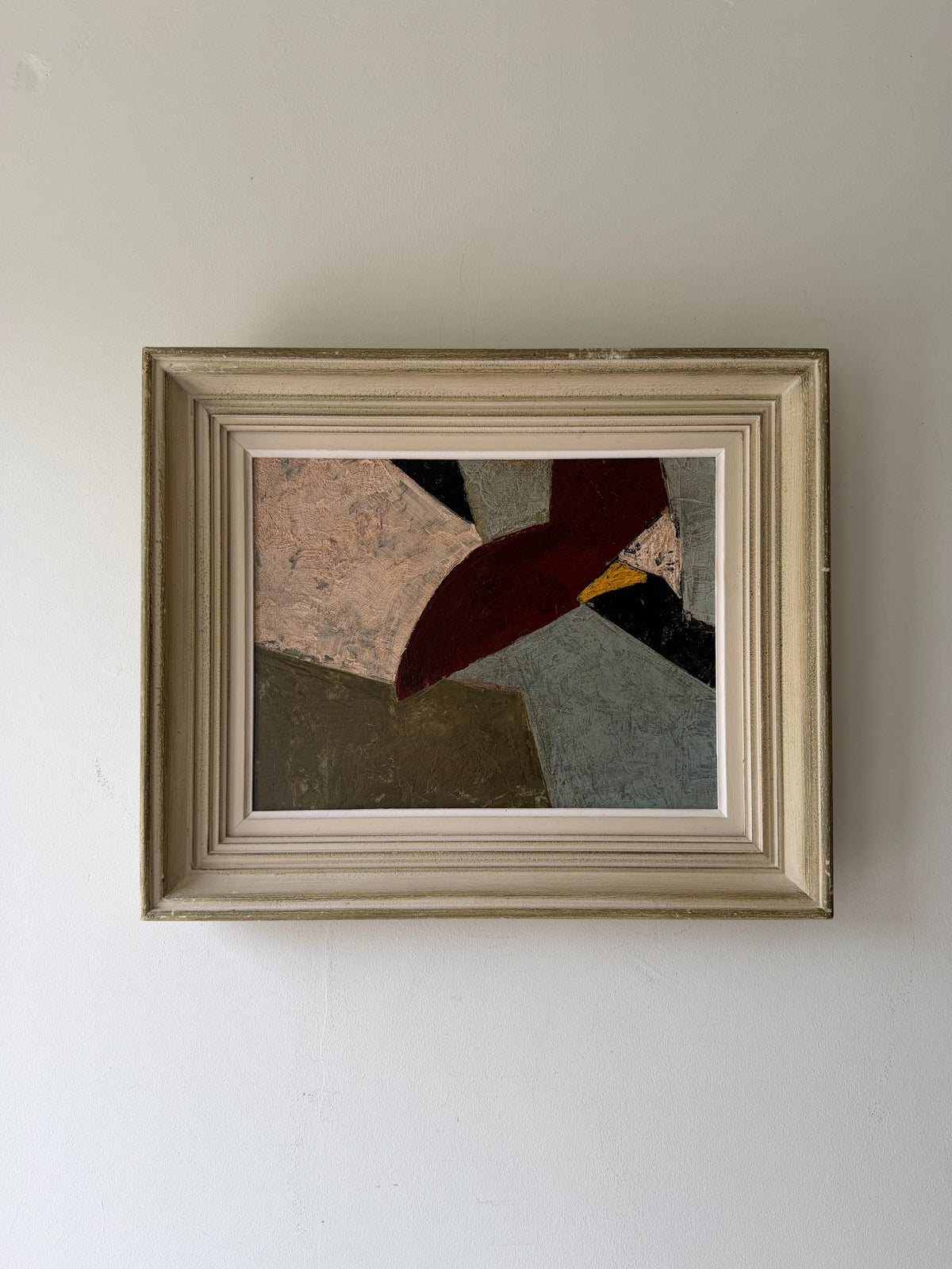 A framed abstract geometric oil painting featuring beige, deep burgundy, grey, and black shapes, housed in a distressed off-white wooden frame. Available at Hue. 