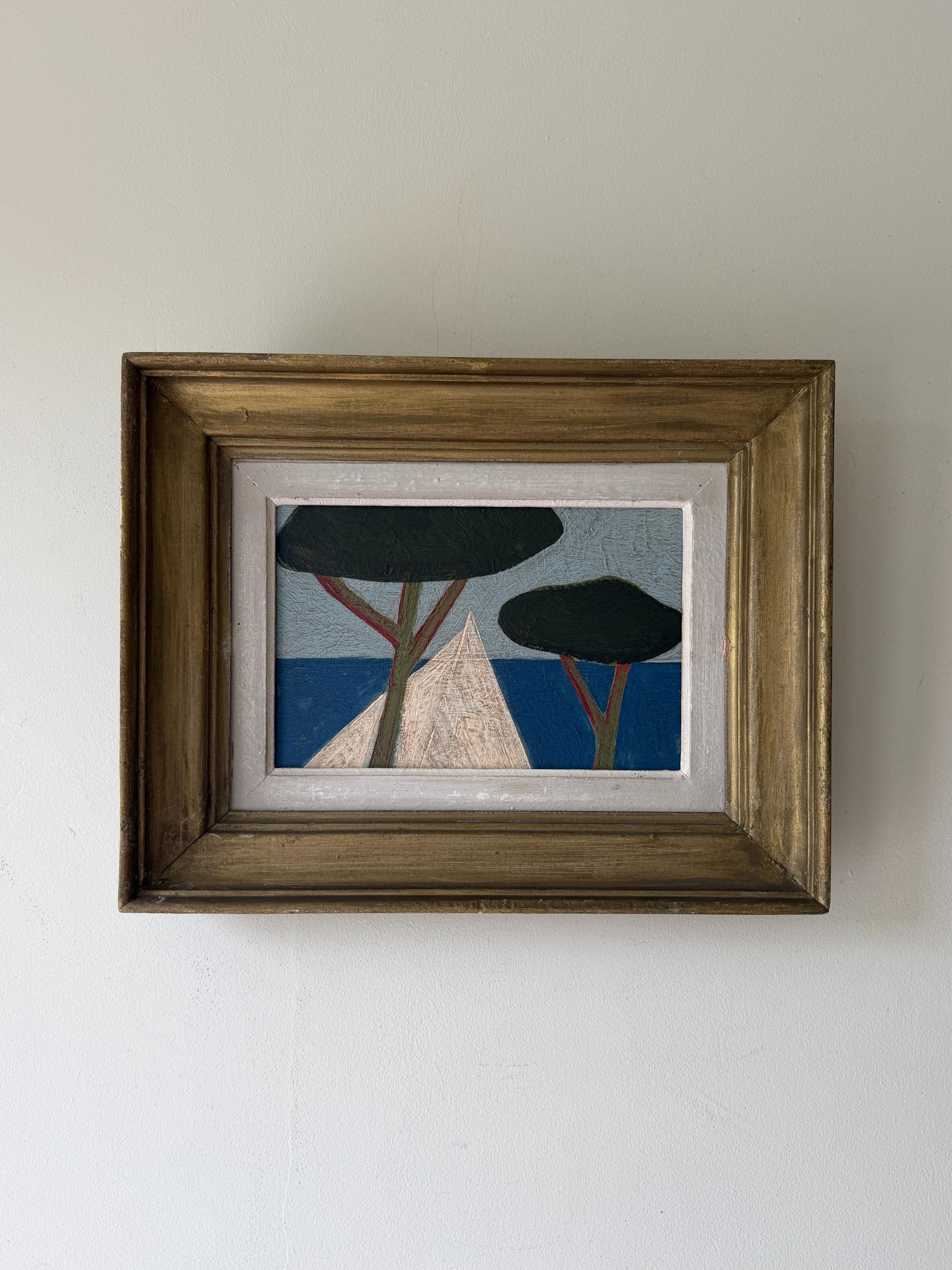 A framed semi-abstract landscape oil painting featuring stylized trees and geometric shapes in blue, black, beige, and brown. Available at Hue. 