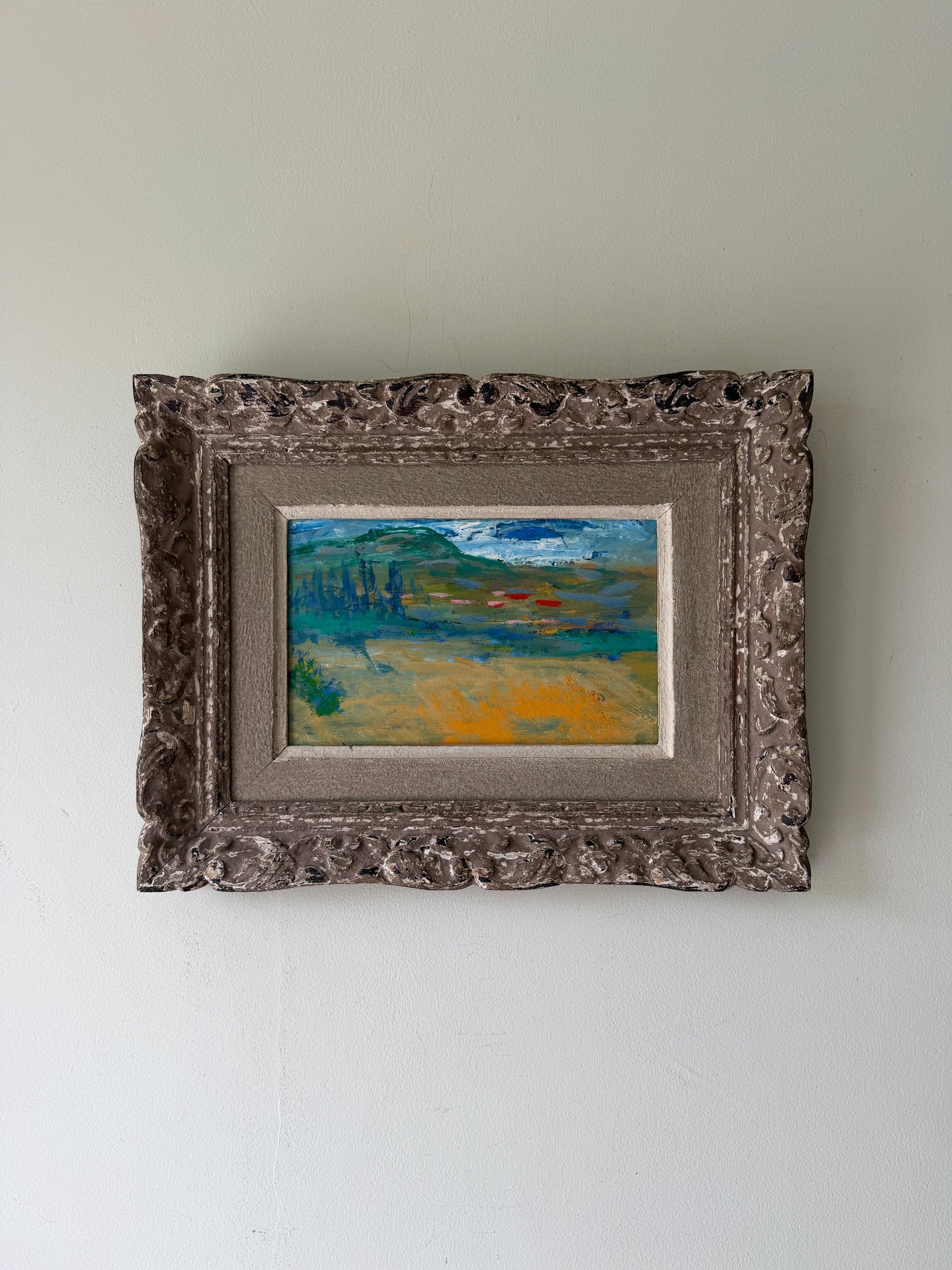 A small framed landscape painting with an ornate, distressed vintage frame. Available at Hue. 