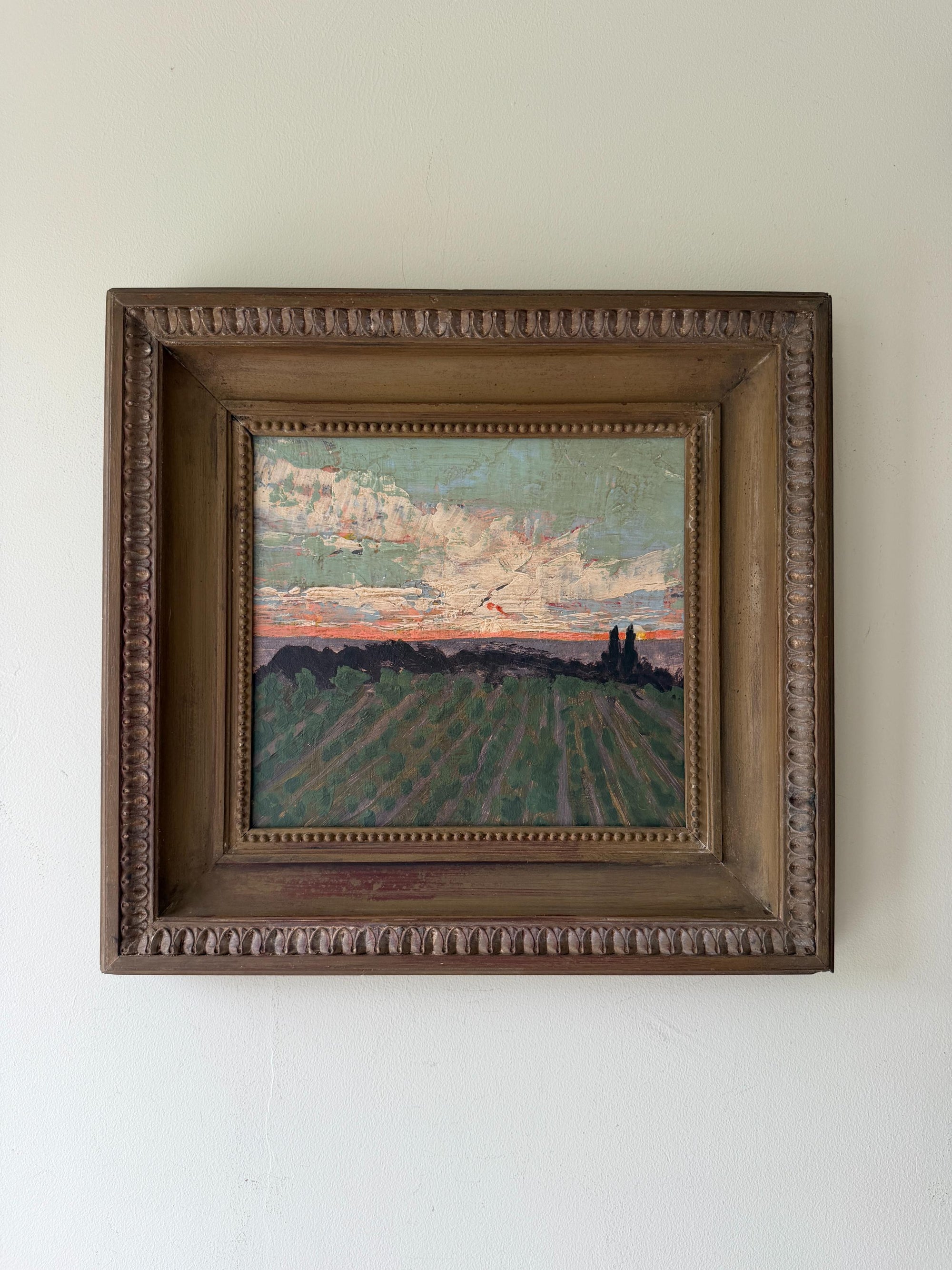 A framed landscape oil painting of a vineyard under an evening sky. Available at Hue. 