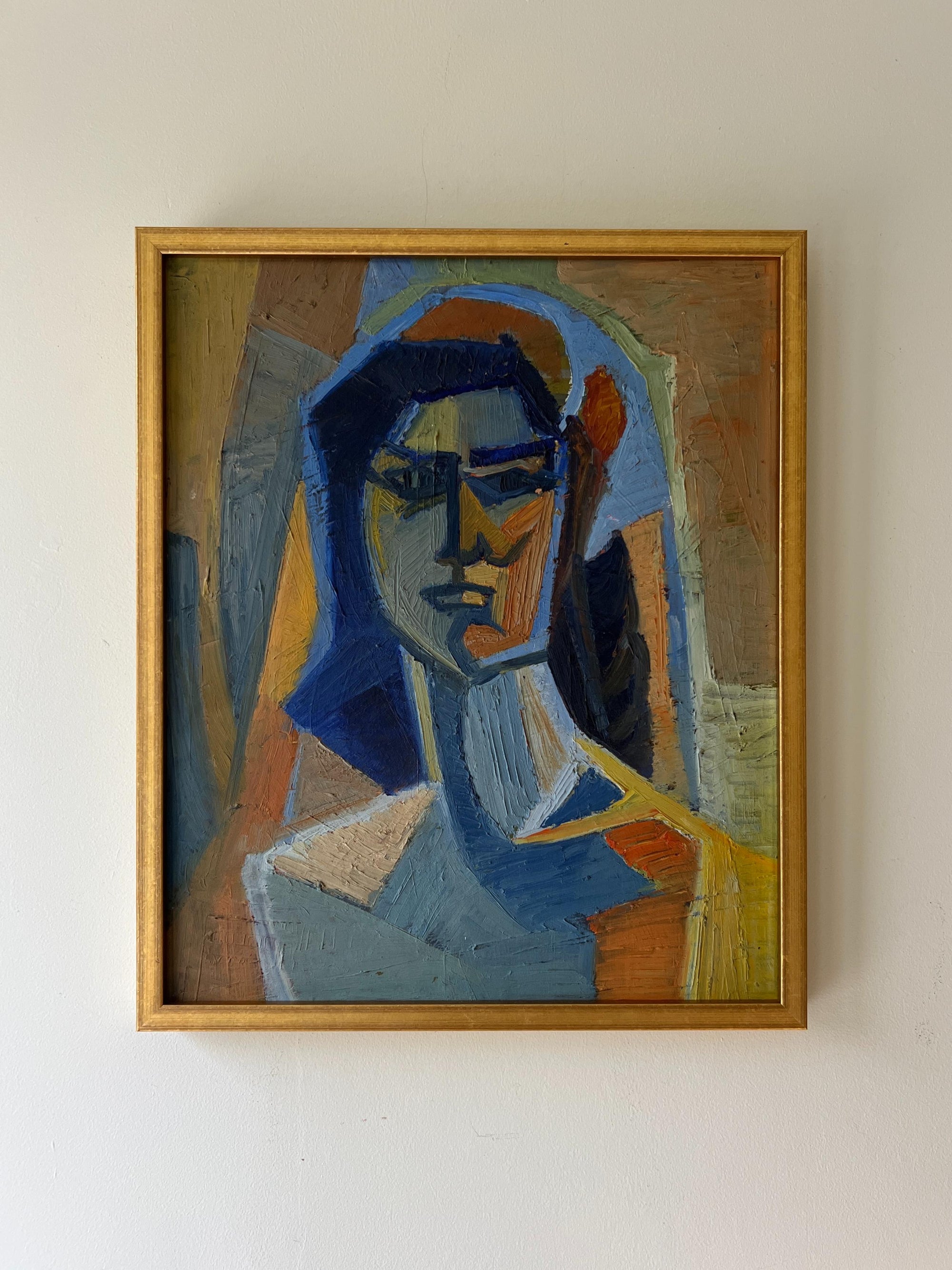 A framed vintage oil painting of a female portrait in a cubist style with ochres and blues. Available at Hue. 