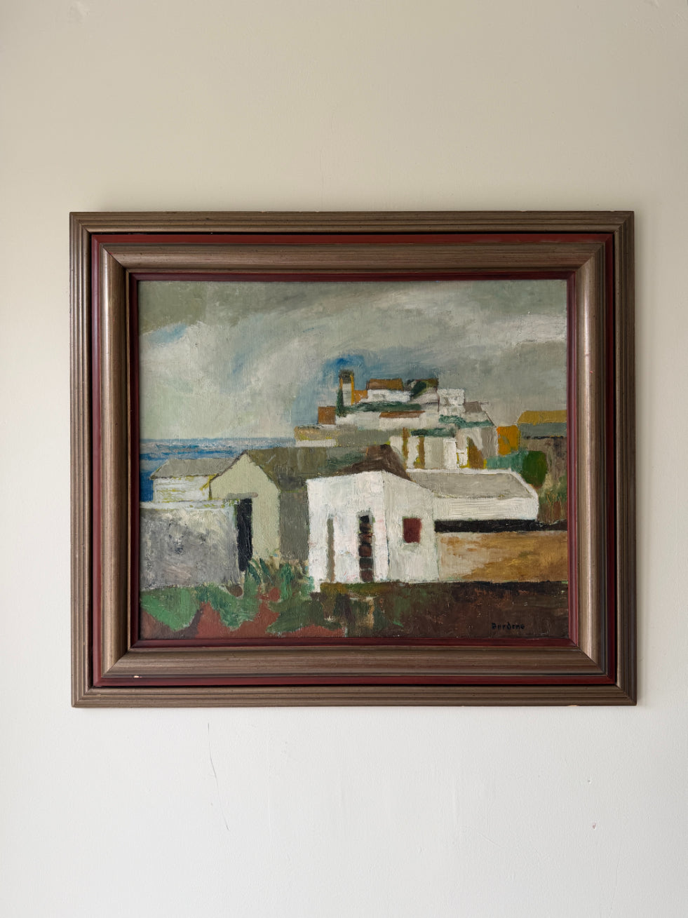Framed vintage oil painting of a coastal scene with whitewashed buildings. Available at Hue. 