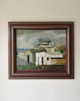 Framed vintage oil painting of a coastal scene with whitewashed buildings. Available at Hue. 