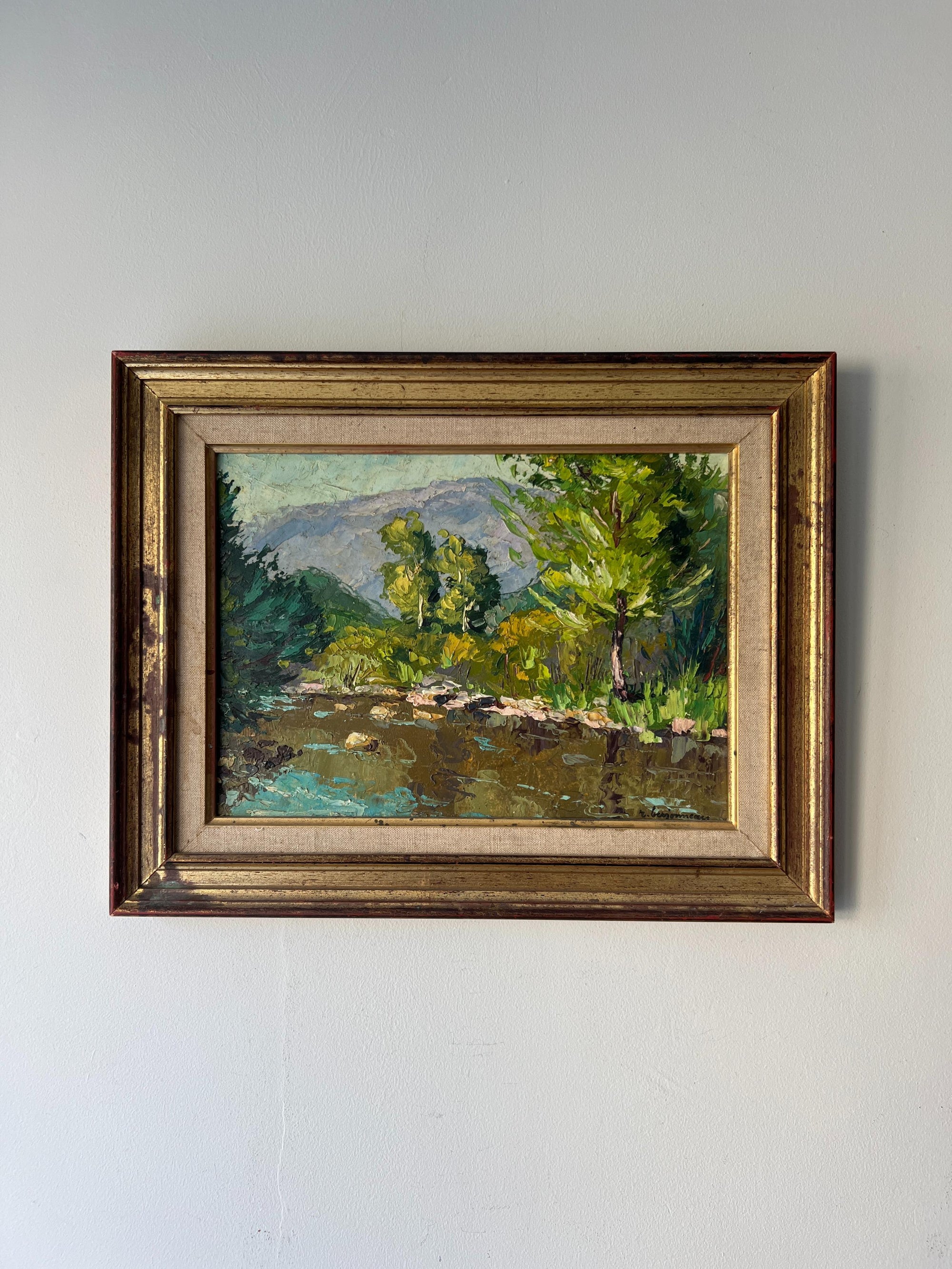 Framed vintage oil painting of a riverside landscape with trees and water. Available at Hue. 
