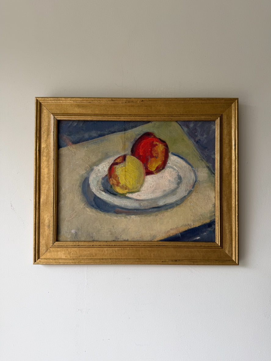 A framed vintage still life oil painting of two apples on a plate. Available at Hue.