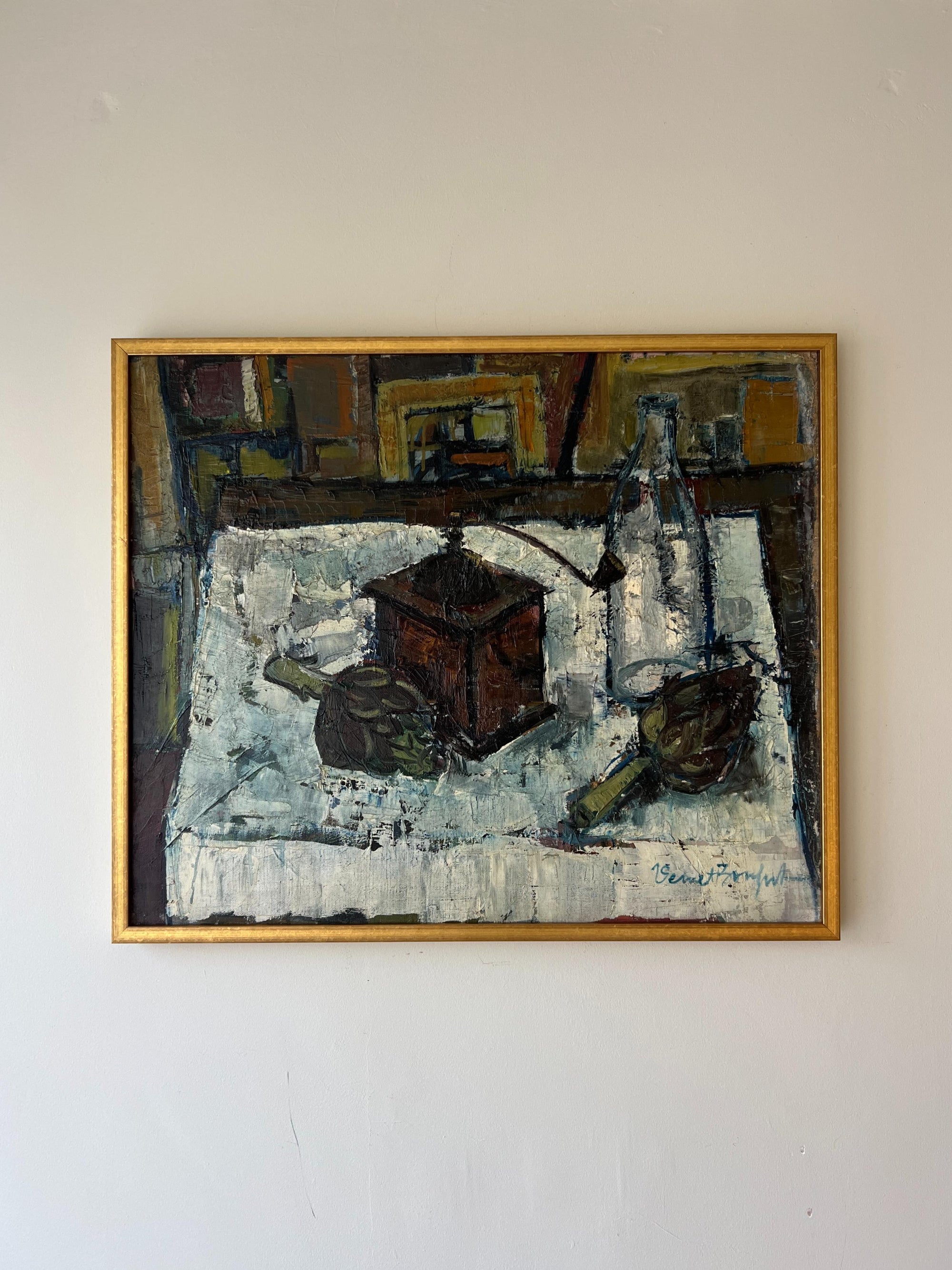 A framed vintage oil painting of a still life scene in a kitchen with artichokes and a coffee grinder. Available at Hue. 