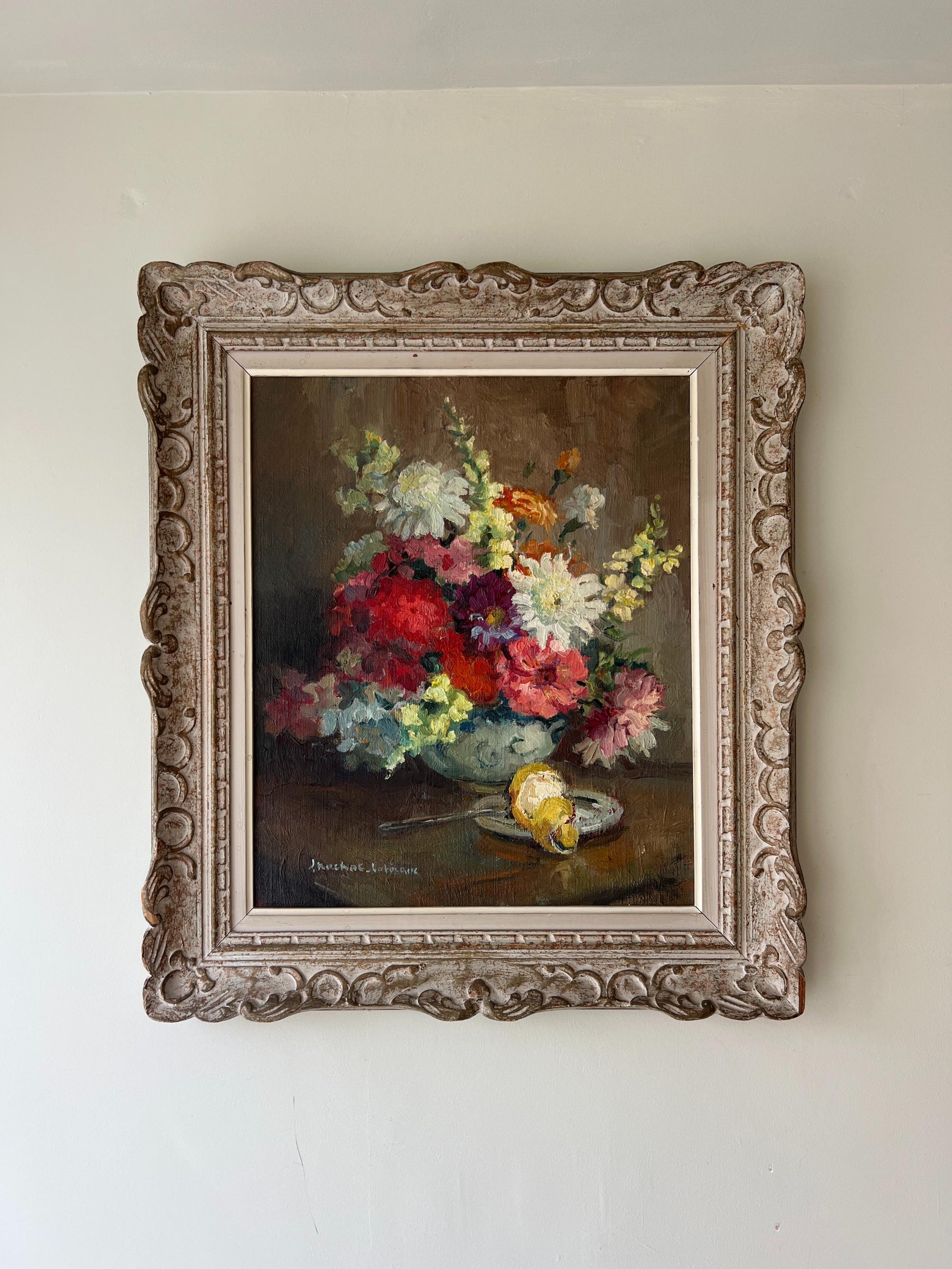 A vintage oil painting of a vibrant bouquet of flowers in a vase on a table.  Available at Hue.