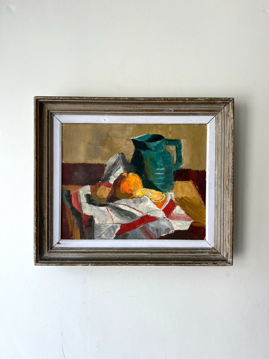 Framed vintage still life oil painting with a teal green pitcher and fruits on a striped cloth. Available at Hue. 