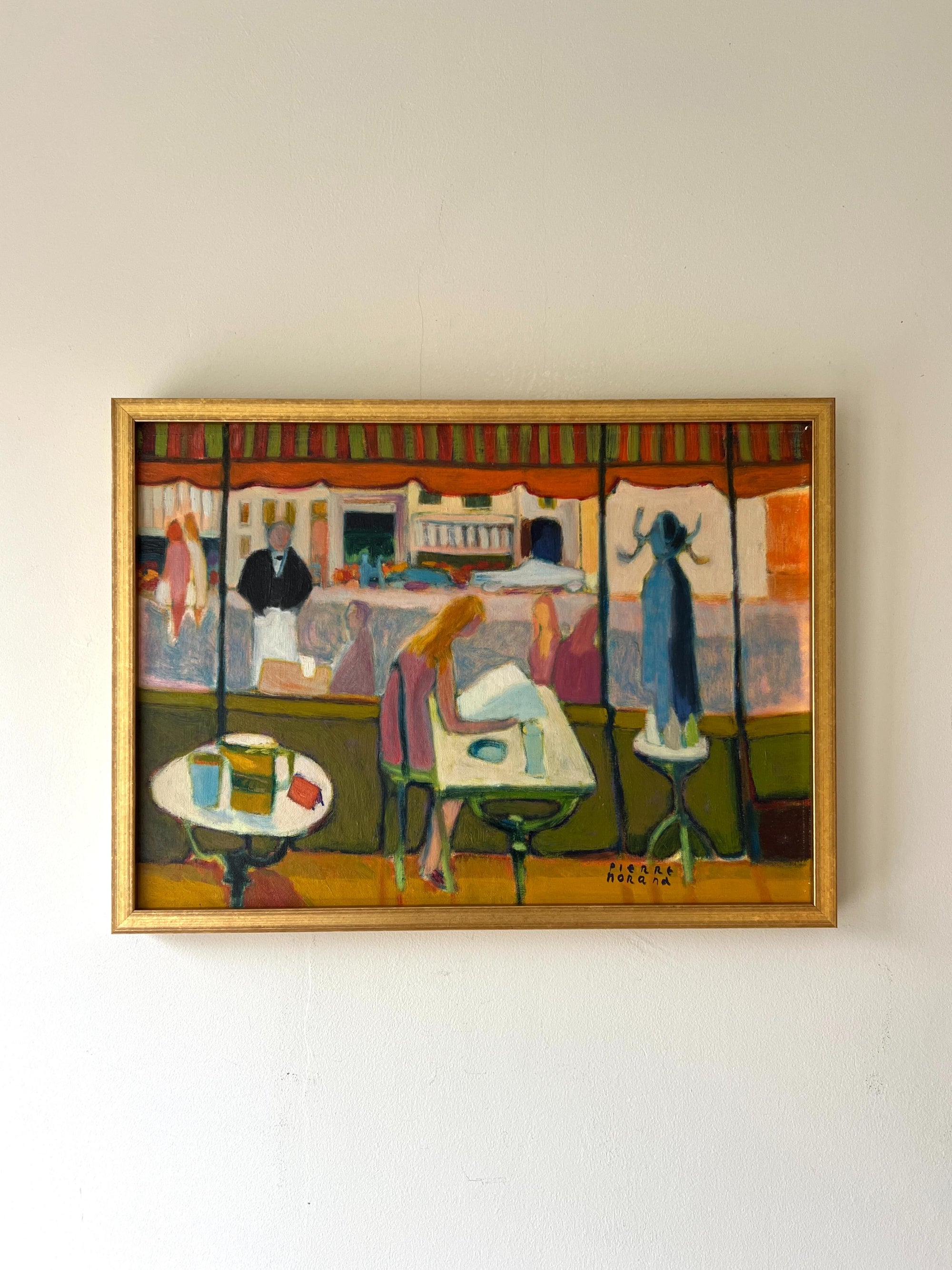 A framed vintage oil painting of a french cafe scene with vibrant colours. Available at Hue.
