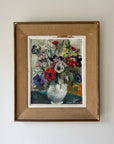 A framed vintage oil painting of a lively, bright bouquet of flowers in reds, blues and yellows. Available at Hue. 