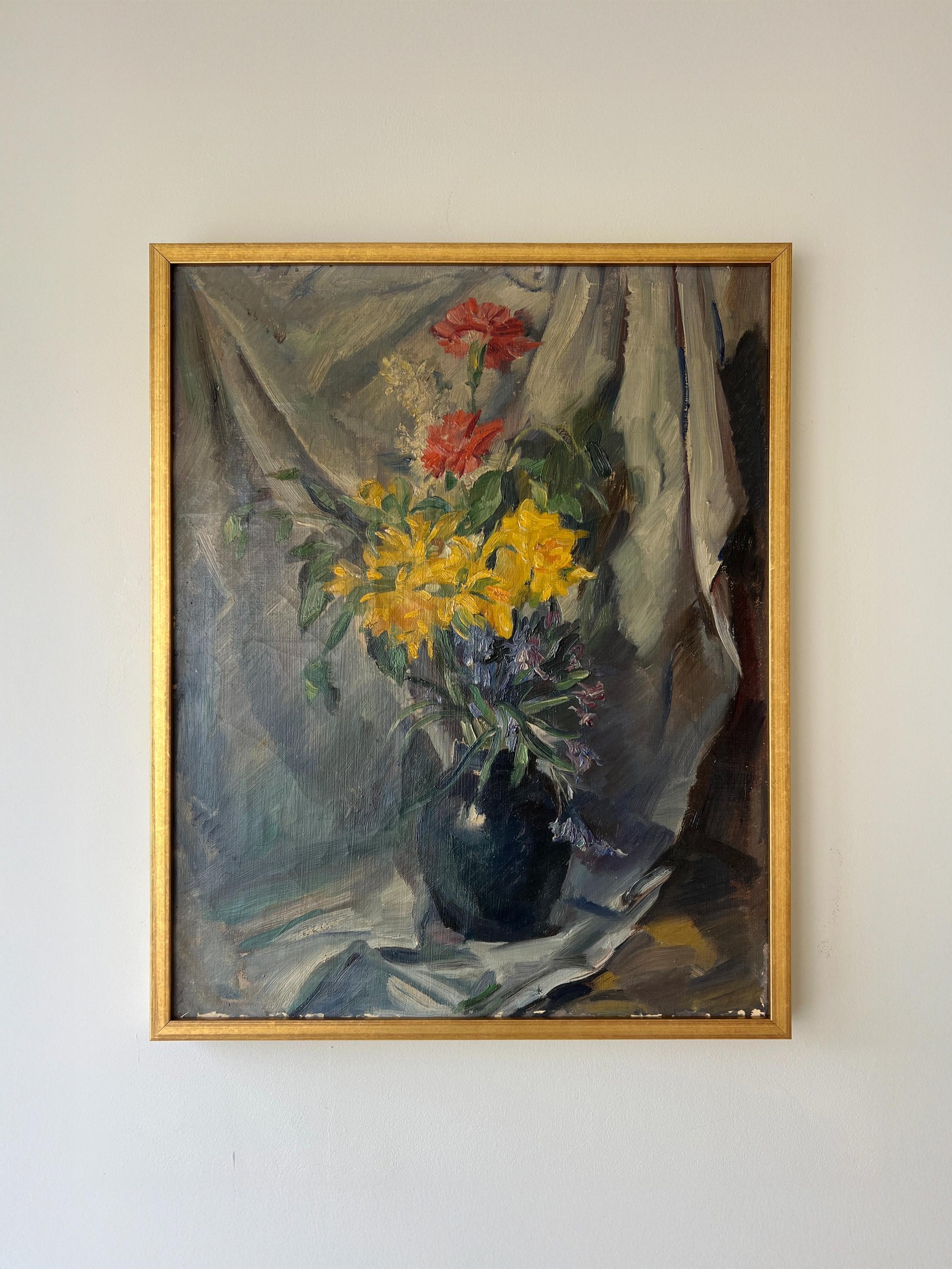 A framed vintage oil painting of red, yellow and blue flowers in a vase. Available at Hue. 