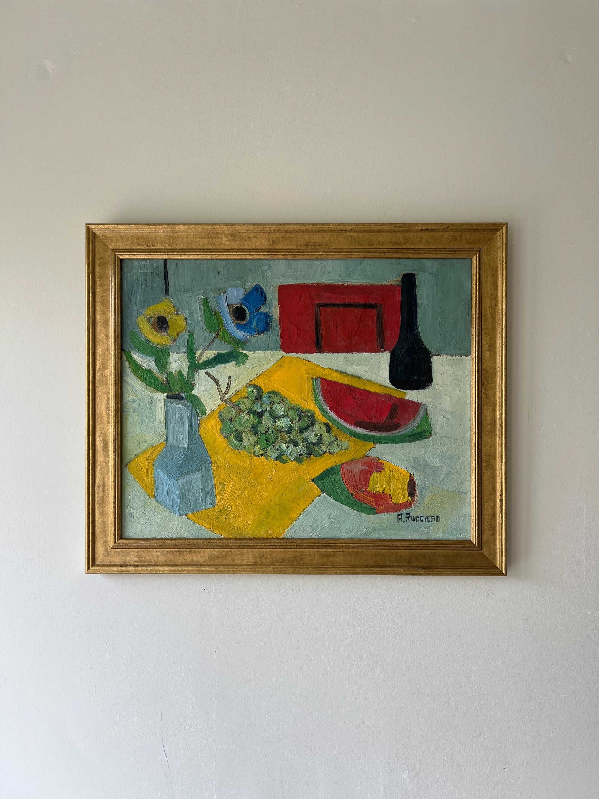 A framed vibrant vintage oil painting of a tabletop study with fruit and florals. Available at Hue. 
