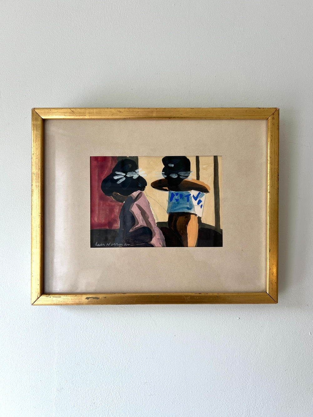 Framed painting of two asian figures with a gold frame on a white wall available from hue