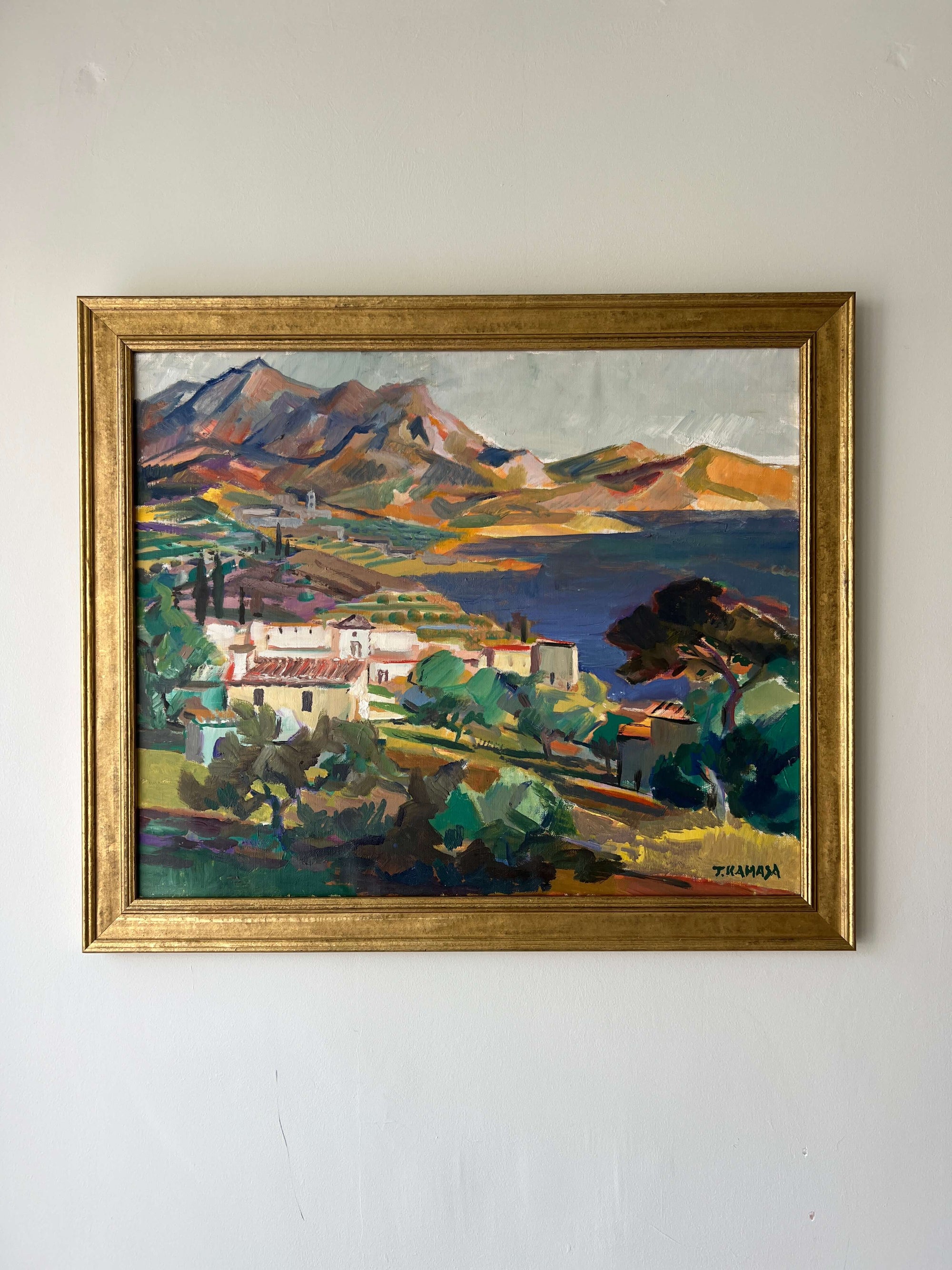 Framed, vintage oil painting on canvas of a mountainous coastal landscape with houses. Impressionist style, available at Hue.