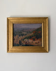 A framed vintage landscape oil painting of a hillside village with green trees and terraced hills. Available at Hue. 