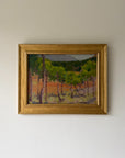 A framed vintage oil landscape painting featuring green trees and a warm orange-terracotta field. Available at Hue.