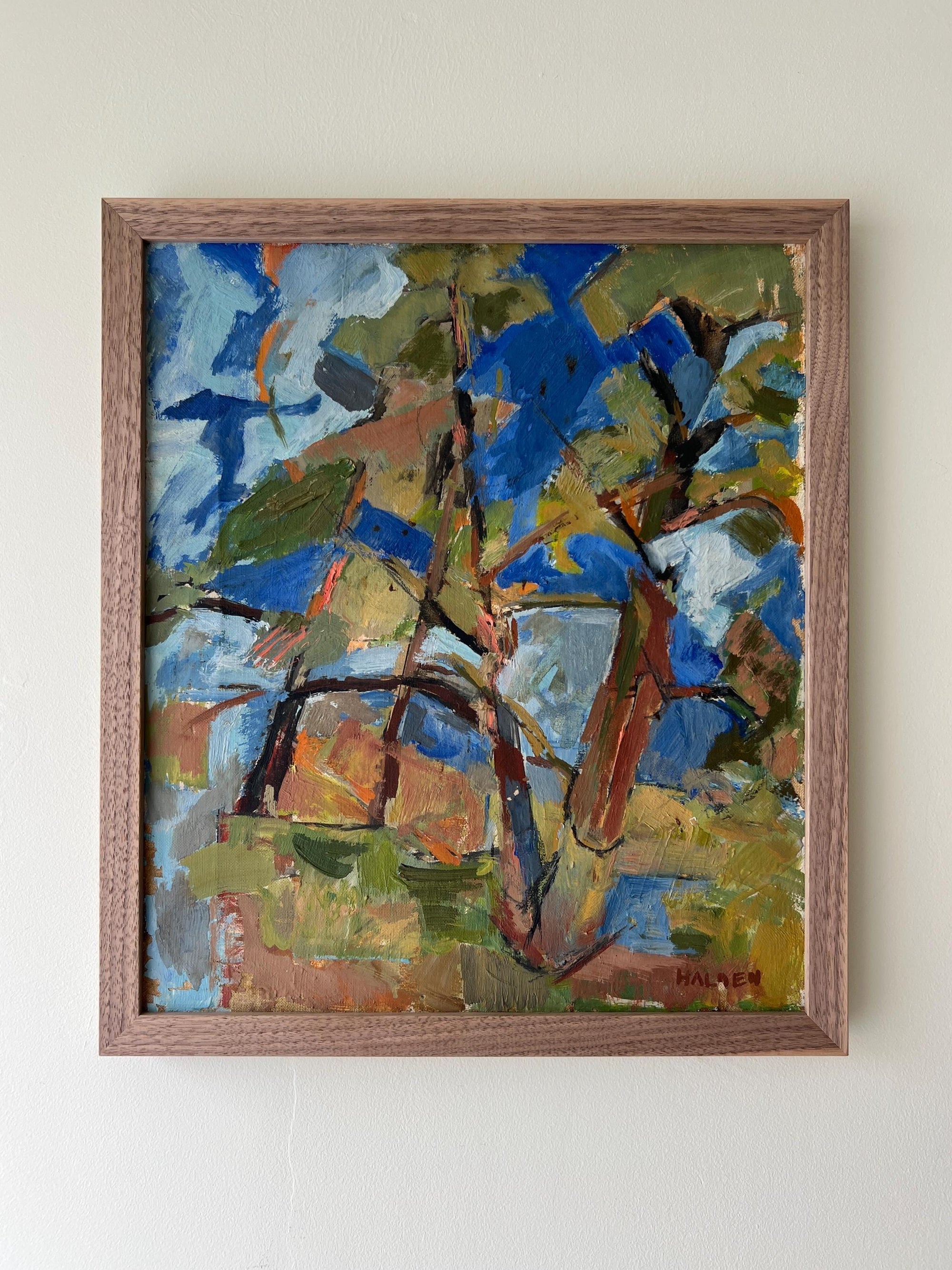 Framed vintage abstract painting of pine trees with blue, green, and brown colours in a solid walnut frame, available at Hue