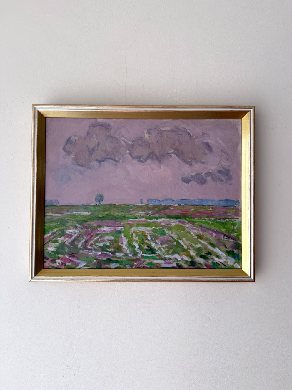 Framed vintage oil painting of a landscape with fields and clouds. Available at Hue. 