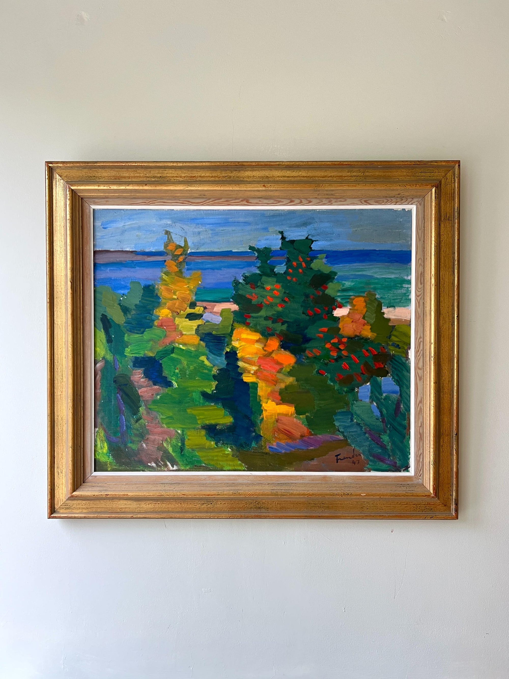 A framed vintage oil painting of a bright coastal scene. Available at Hue. 