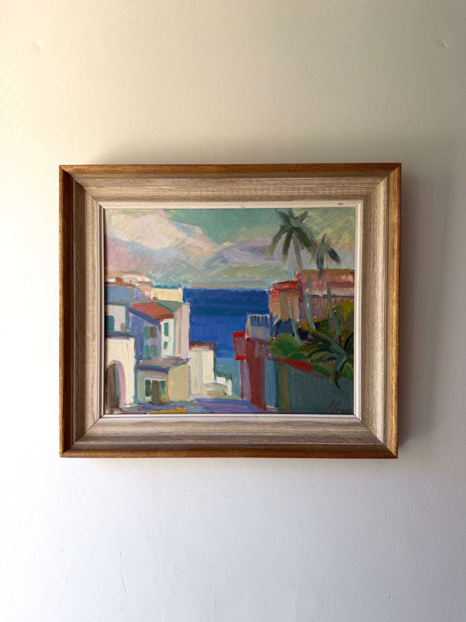 Framed vintage oil painting of a coastal scene with buildings and palm trees. Available at Hue. 