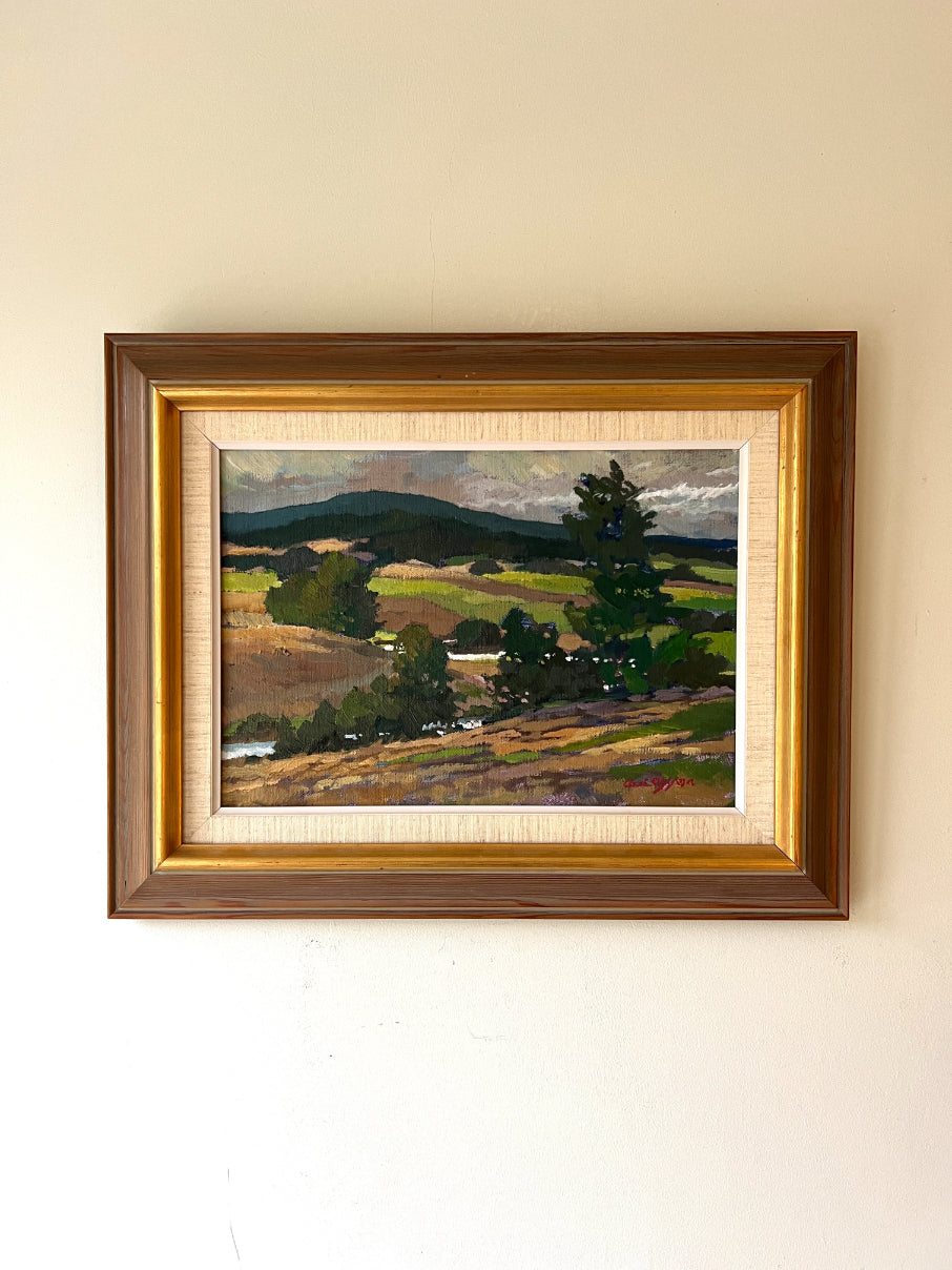 Framed vintage landscape oil painting of a countryside vista. Available at Hue. 