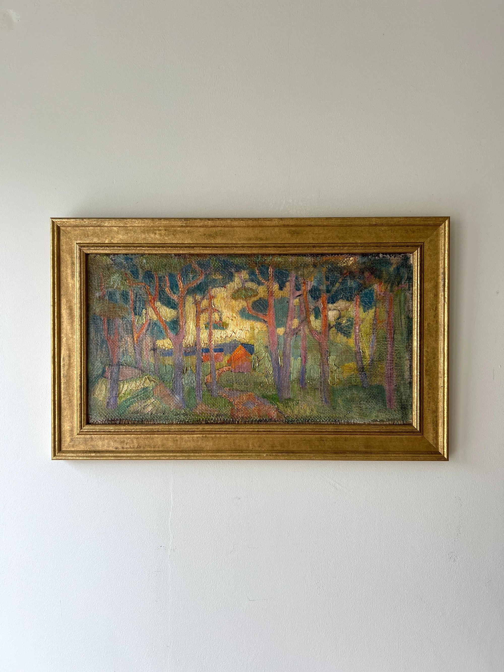 A framed vintage oil painting of a forest landscape with dense, tall pine trees and a warm light, available at Hue.