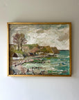 Framed vintage oil painting of a coastal scene with rocks, trees and a small white cottage, available at Hue.
