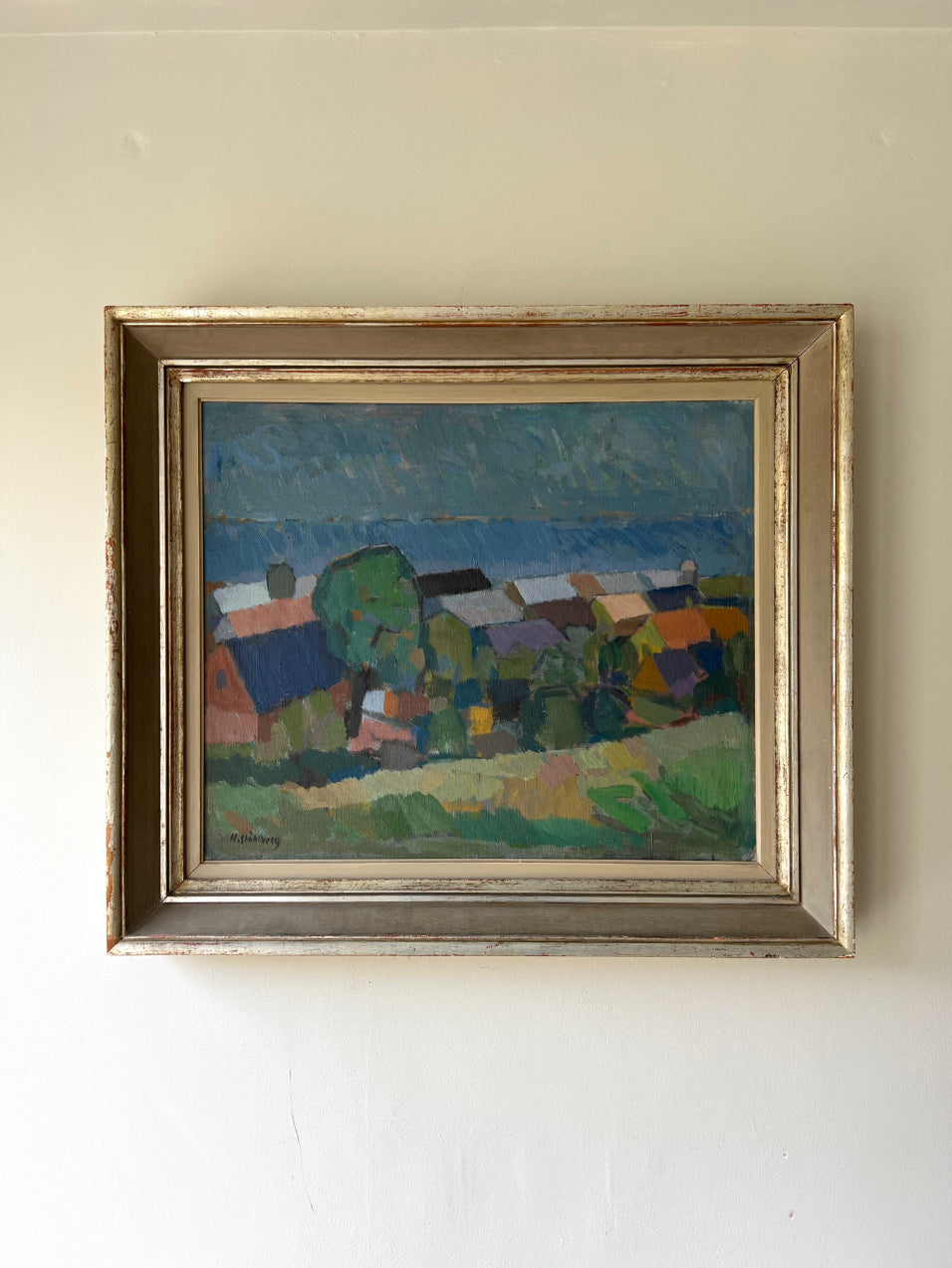 Framed vintage oil painting of a landscape with coastal houses and trees. Available at Hue.