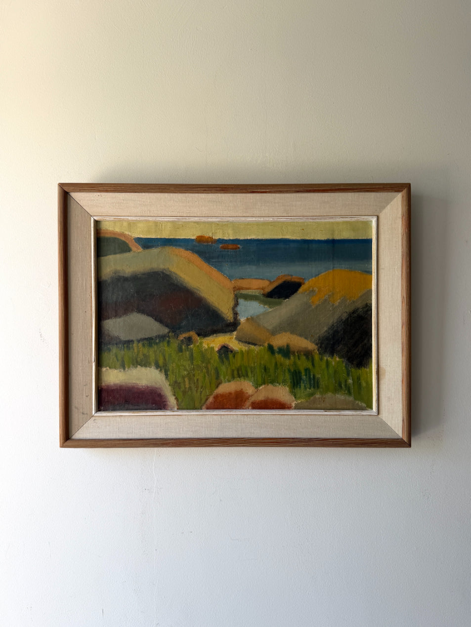Framed vintage oil painting of a landscape with hills and a body of water. Available at Hue. 