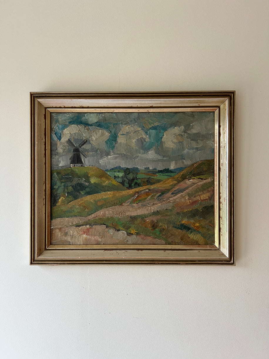 Framed vintage landscape oi painting of a windmill on a hillside with clouds. Available at Hue. 